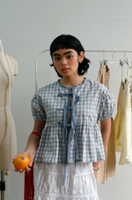Woman holding an orange in a clothing store